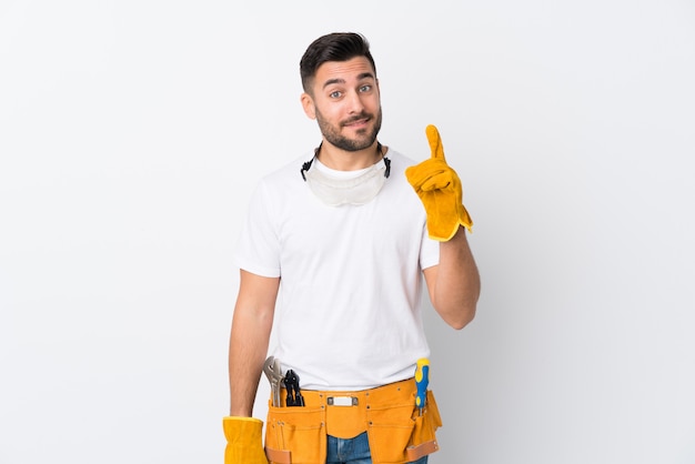 Craftsmen or electrician man over isolated white wall pointing with the index finger a great idea