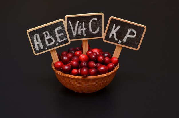 Cranberries and tablets with the names of the vitamins contained in the berries