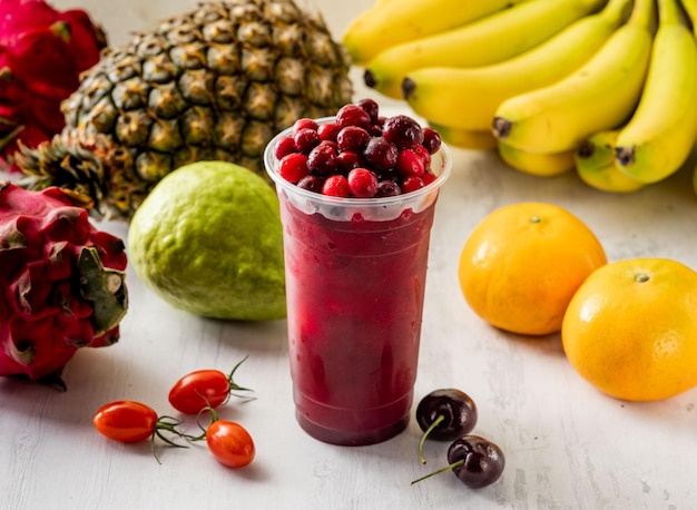 Cranberry juice with raw fruits served in disposable glass isolated on background top view taiwan food