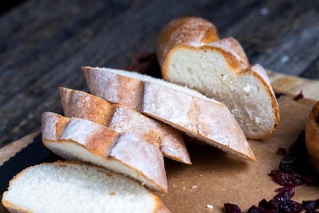 Cranberry and sliced soft fresh baguette on a cutting board and table