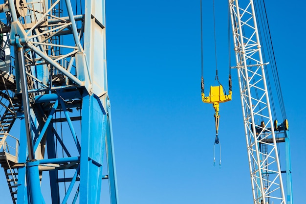 Crane boom with a stabilizer and a hook against a blue sky