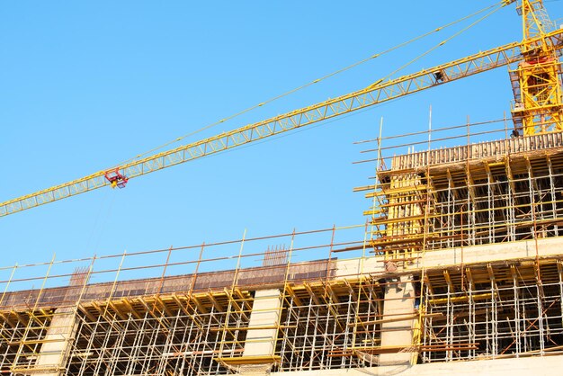 Crane and building construction site against blue sky Construction of new residential highrise building