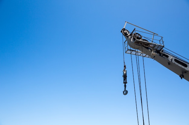 Crane with risen boom on blue sky