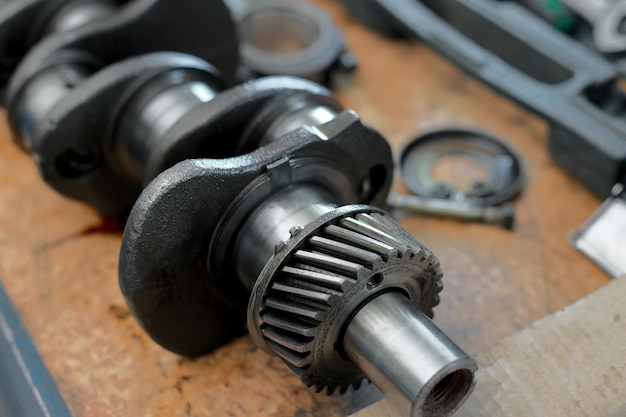 The crankshaft of the car with gears is on the table