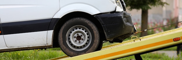 Crashed car is immersed in tow truck closeup. Car evacuation after an accident concept