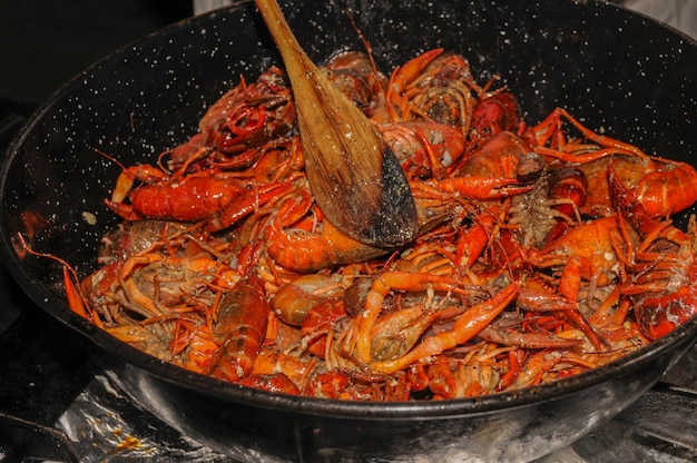 Crayfish are cooked in water in a saucepan on the kitchen stove crayfish are red from cooking