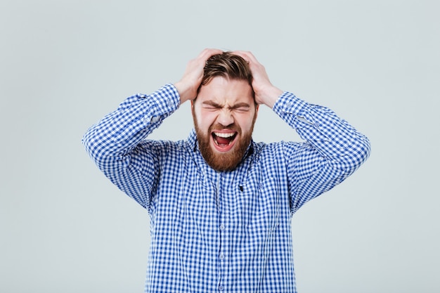 Crazy mad young man standing and shouting