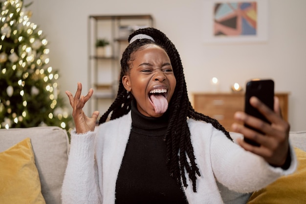 Crazy pretty girl of african beauty with dreadlocks and a wonderful smile relaxes on the couch