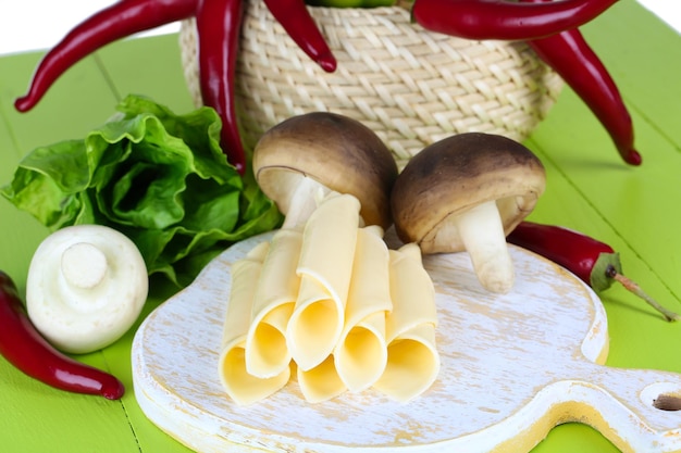 Cream cheese with vegetables and greens on wooden table closeup