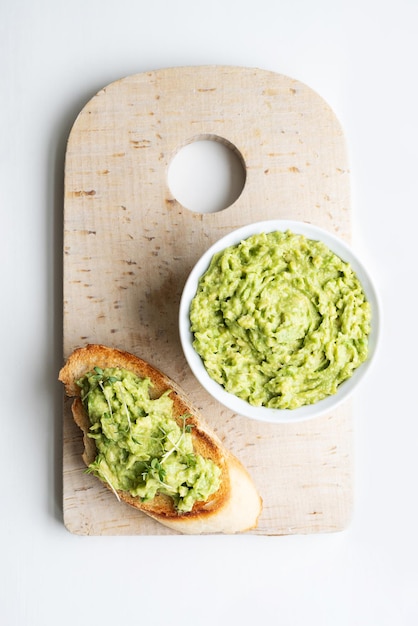 Cream made from avocado on toast with a bowl of guacamole