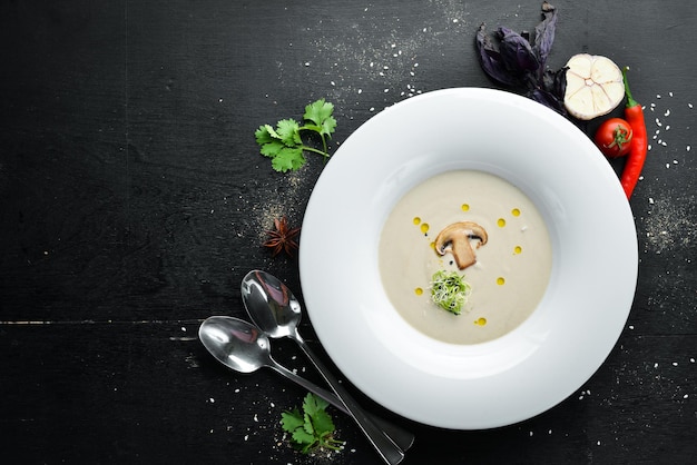 Cream soup of mushrooms. On a wooden background. Top view. Free space for your text.