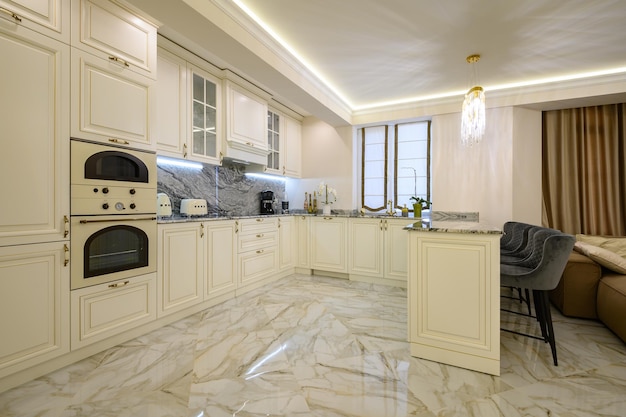 Creamcolored classic kitchen with island serving as dining area in studio apartment