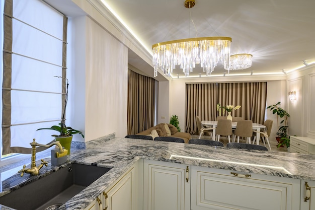 Creamcolored classic kitchen with island used as dining area in studio flat