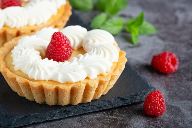 Creamy cheesecake cake with raspberries on a gray table