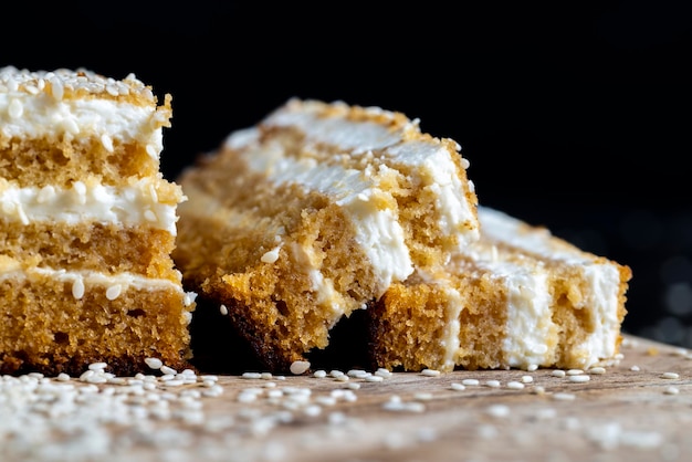 Creamy cream and caramel cakes sprinkled with sesame seeds during dessert preparation layered cake with sesame seeds