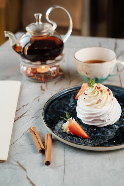 Creamy dessert with strawberries and tea