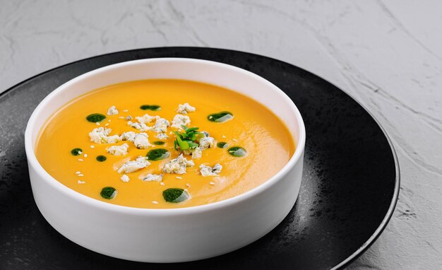 Creamy pumpkin soup in elegant white bowl