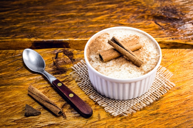 Creamy rice pudding sprinkled with cinnamon, typical Brazilian dessert.