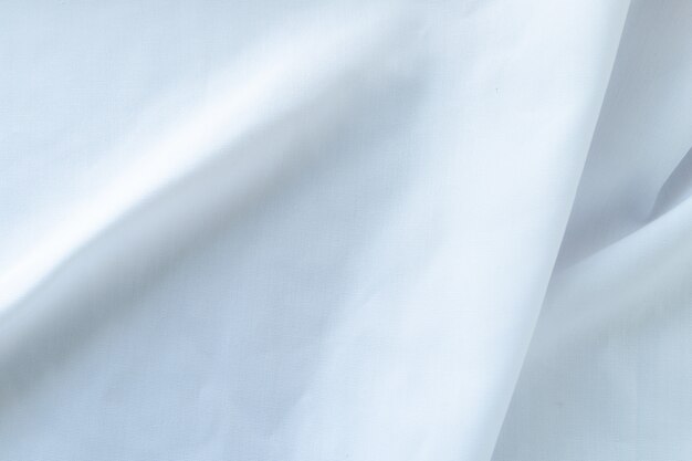 Creased white cloth material fragment as a background.