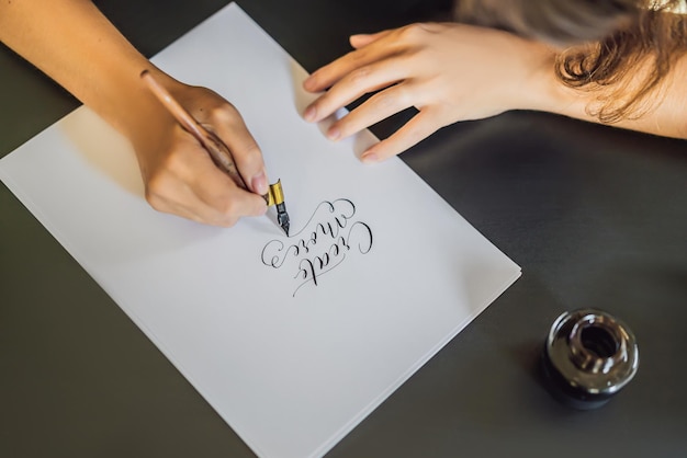 Photo creat more calligrapher young woman writes phrase on white paper inscribing ornamental decorated letters calligraphy graphic design lettering handwriting creation concept