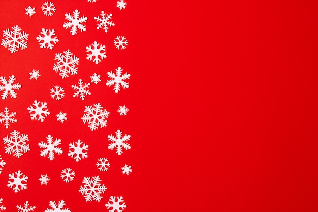 Creative arrangement of christmas decoration snowflakes on red