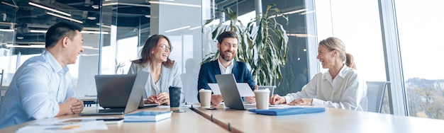 Creative business people working on project in modern office with panoramic view