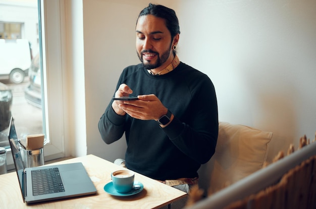 Creative businessman laptop and speaker phone for communication social media or networking at cafe Happy employee male with smile holding smartphone for voice call or startup at the coffee shop