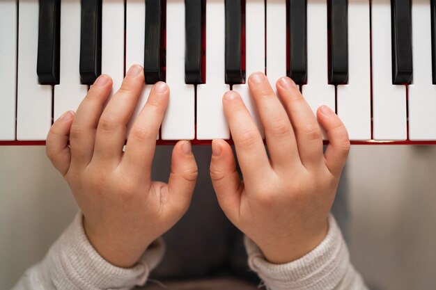 Creative child plays the synthesizer. Little girl learning to play the piano.