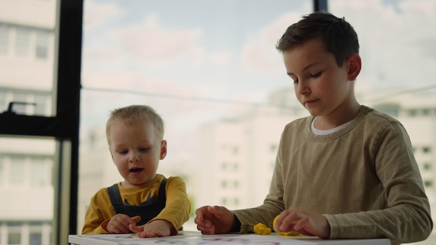 Creative children modeling from plasticine at home Siblings playing indoors