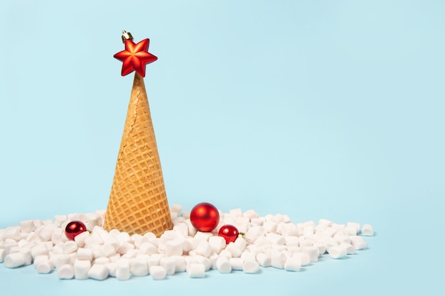 Creative Christmas tree made from ice cream waffle cone. Snow is made from marshmallows.