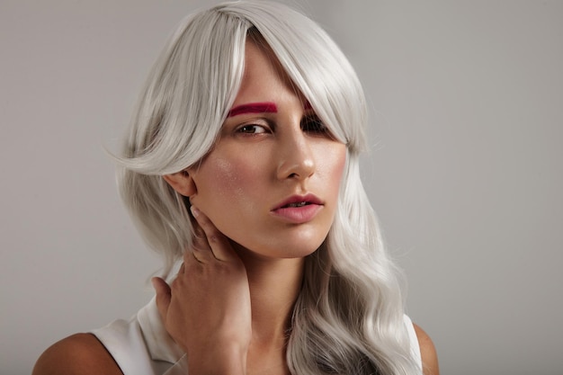 Creative coloured hair of model grey hair pink brows