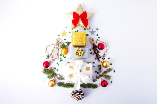 Creative composition of Christmas tree made of Christmas decorations on white flat lay top view