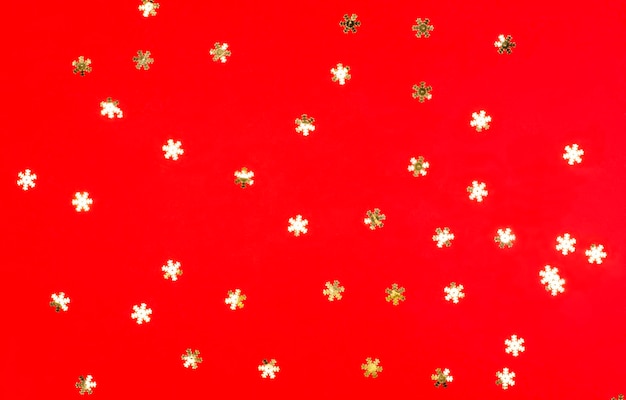 Creative composition of golden snowflakes of Christmas decoration on a red background Holiday concept Flat lay top view Perfect Christmas background