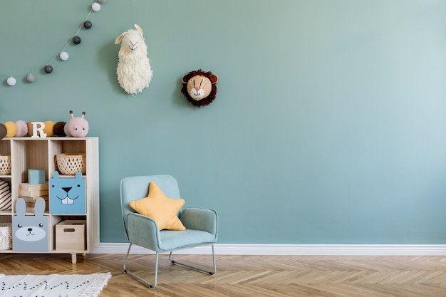 Creative composition of stylish and cozy child room interior design with eucalyptus wall, plush toys, furniture and accessories. Parquet floor. Copy space. Template.