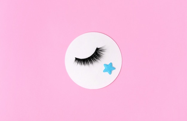 Creative composition with eyelashes on pink background