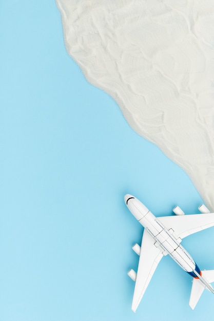 Creative composition with toy airplane and sand. Travel vacation concept