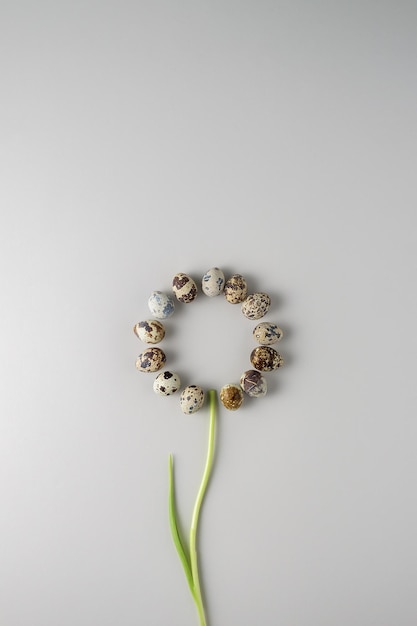 Creative concept of a happy Easter on a gray background Spring flower with egg petals Top view