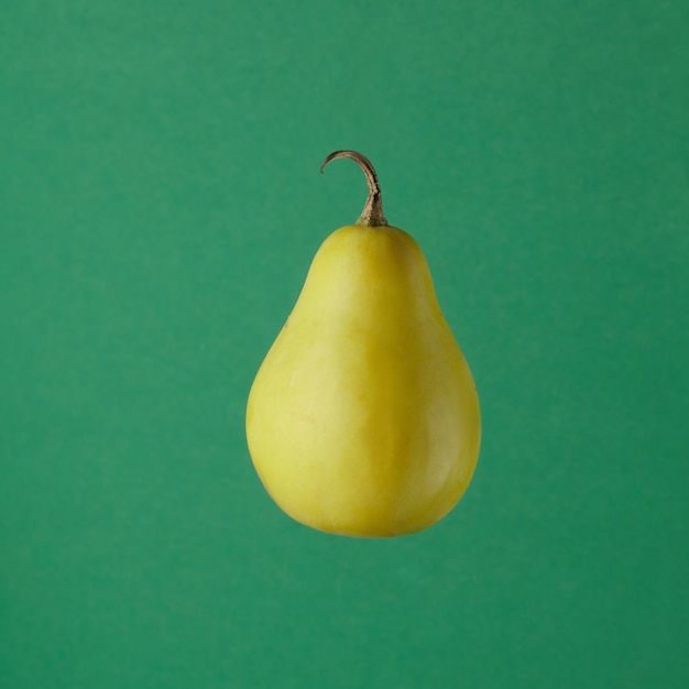 Creative concept with flying pear isolated on green