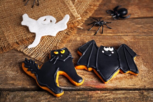 Creative cookies for Halloween party on wooden table close up