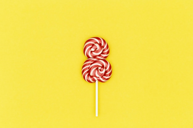 Creative Day Womens day minimal composition with sweet red lollipop in shape of eight