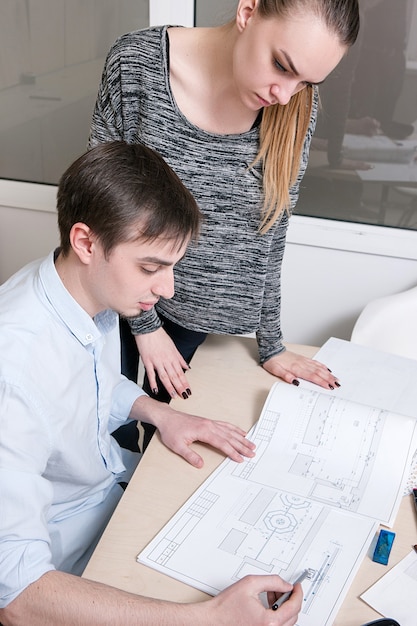 Creative designers working process. Man and woman discussing sketches in office interior