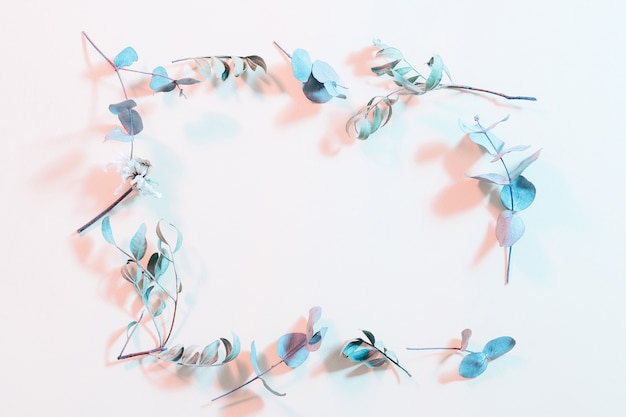 Creative dried foliage layout. Inverted colors design. Blue stems frame on ivory