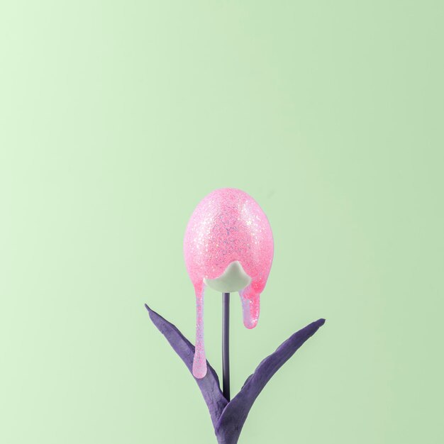 Photo creative easter concept tulip with a bud in the form of an egg with glitter paint running down it