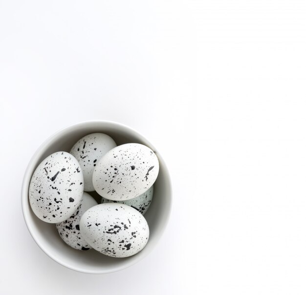 Creative Easter template made of painted eggs in bowl on white background