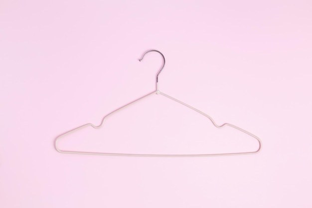 Creative flat lay hanger pastel pink background Sale discount store promo shopping concept Top view