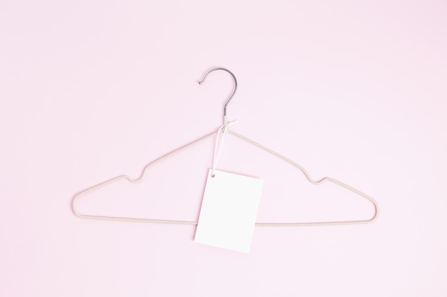 Creative flat lay hanger with white paper label Clothing tag label blank mockup template