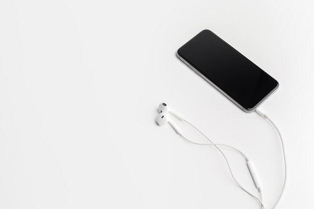 Creative flat lay photo of workspace desk with earphones and mobile phone