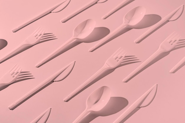 The creative flat lay of plastic forks spoons and knifes pattern