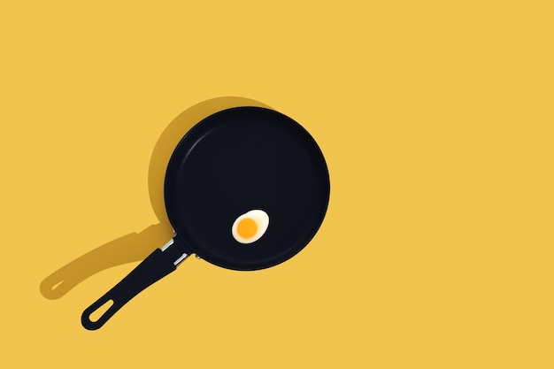 Creative food concept with gummy candy fried egg shaped on black frying pan over yellow background Morning breakfast top view Seamless pattern minimal style Flat lay Copy space