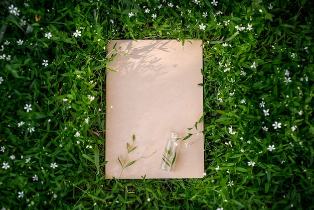 Creative green floral background of natural leaves and meadow grass. Kraft paper frame.